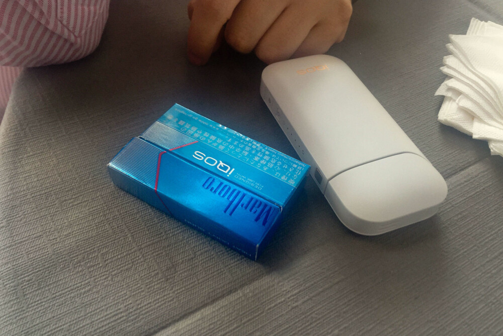 RØYKEMASKIN: Iqos i pakke med kjent varemerke. Den hvite innretningen inneholder og lader munnstykket som varmer opp selve røyken. Batteriet i munnstykket holder i seks minutter eller 14 trekk, skriver japanske Nikkei, Deretter må den tilbake i boksen sin for å lades opp igjen. RØYKEMASKIN: Iqos i pakke med kjent varemerke. Den hvite innretningen inneholder og lader munnstykket som varmer opp selve røyken. Batteriet i munnstykket holder i seks minutter eller 14 trekk, skriver japanske Nikkei, Deretter må den tilbake i boksen sin for å lades opp igjen.