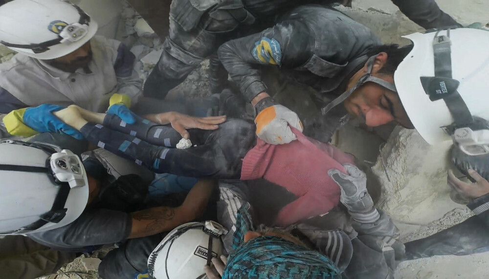 REDDET: En skadet gutt hentes ut fra ruinene etter en boligblokk raste sammen etter et flyangrep i Aleppo. REDDET: En skadet gutt hentes ut fra ruinene etter en boligblokk raste sammen etter et flyangrep i Aleppo.