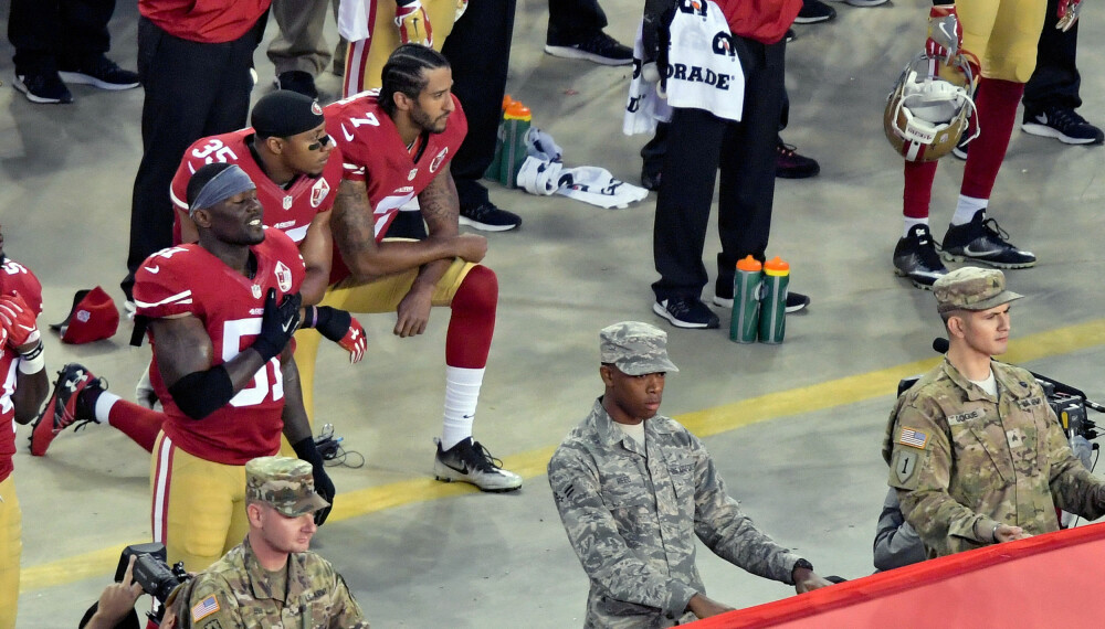 COLIN KAEPERNICK (draktnummer 7) startet bevegelsen. Her har han fått med seg lagkamper Eric Reid (nummer 35) før en kamp i Santa Clara 12. september i fjor. COLIN KAEPERNICK (draktnummer 7) startet bevegelsen. Her har han fått med seg lagkamper Eric Reid (nummer 35) før en kamp i Santa Clara 12. september i fjor.
