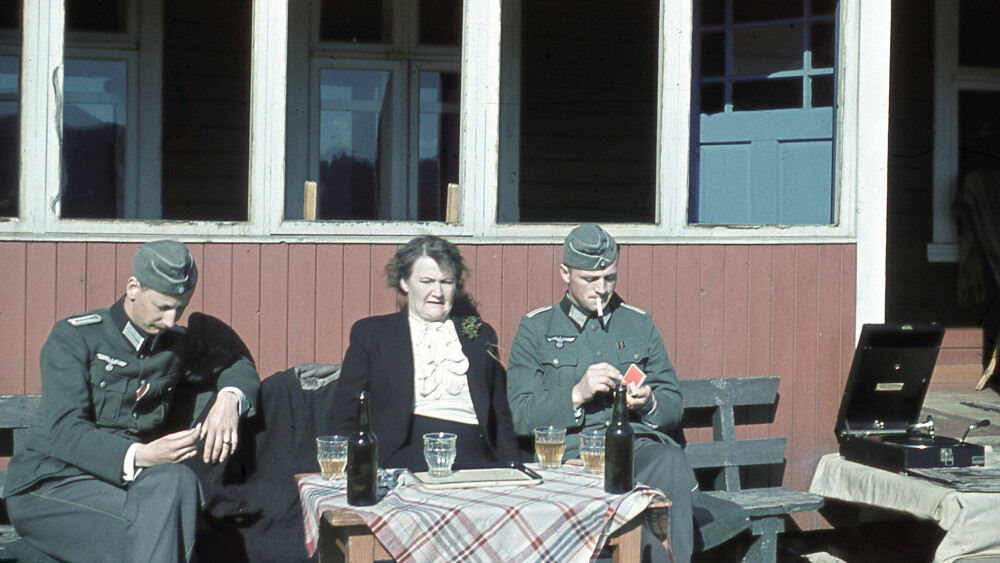 MOT SLUTTEN: Olga Bjoner fotografert i solveggen på ei hytte trolig i sør-Norge et sted, hvor hun nyter et glass sammen med to yngre offiserer. Bildet – som er sjeldent, fordi det er tatt i farger – er antagelig tatt i 1943 eller 1944, og viser en åpenbart sliten kvinne på nærmere 60. MOT SLUTTEN: Olga Bjoner fotografert i solveggen på ei hytte trolig i sør-Norge et sted, hvor hun nyter et glass sammen med to yngre offiserer. Bildet – som er sjeldent, fordi det er tatt i farger – er antagelig tatt i 1943 eller 1944, og viser en åpenbart sliten kvinne på nærmere 60.