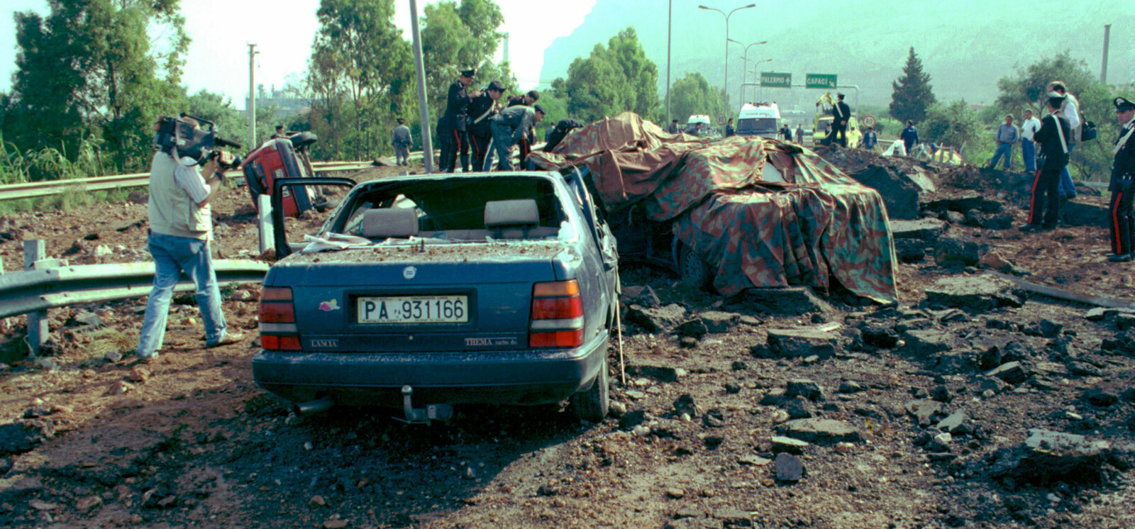 <b>MASSAKREN VED CAPACI:</b> Et 100 meter langt stykke av motorveien ved Capaci utenfor Palermo ble revet i filler av bomben som mafiaen hadde plassert. Livvaktene i de to bakerste bilene overlevde, mens nasjonalhelten Giovanni Falcone og hans kone ble kastet ut av den fremste tildekkede bilen på bildet. <b>MASSAKREN VED CAPACI:</b> Et 100 meter langt stykke av motorveien ved Capaci utenfor Palermo ble revet i filler av bomben som mafiaen hadde plassert. Livvaktene i de to bakerste bilene overlevde, mens nasjonalhelten Giovanni Falcone og hans kone ble kastet ut av den fremste tildekkede bilen på bildet.