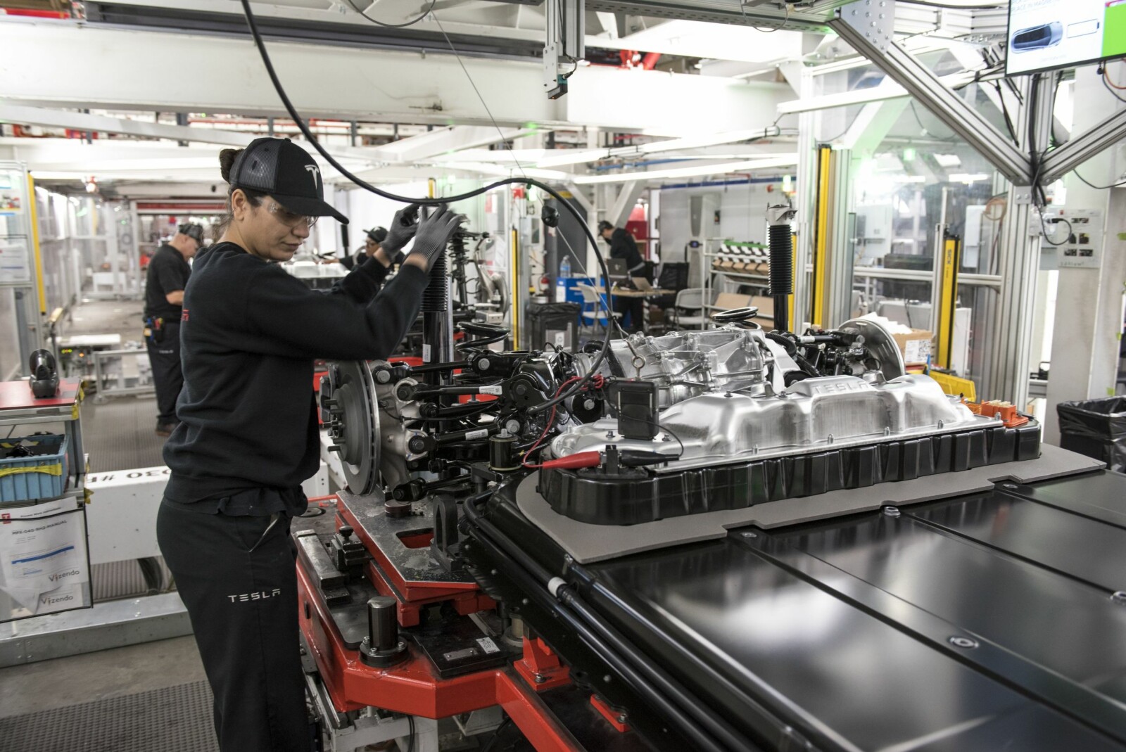 <b>MANUELT:</b> Også manuelt arbeid er en viktig del i produksjonen. Jaqueline dos Santos jobber med sammenstilling av batteri og chassis på en Model S. Hun er en av 10 000 ansatte på to skift. <b>MANUELT:</b> Også manuelt arbeid er en viktig del i produksjonen. Jaqueline dos Santos jobber med sammenstilling av batteri og chassis på en Model S. Hun er en av 10 000 ansatte på to skift.