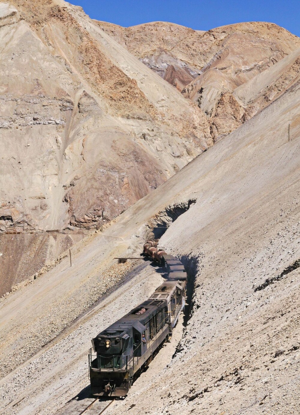 TIL VÆRS: Et tog på Ferronor-banen klatrer opp de bratte bakkene til Potrerillos-kobberraffineriet nær Diego de Almagro i Chile. Dette er en av de mest iøyenfallende delene av linja mellom Montandon og Potrerillos. Smelteverket ligger 2900 meter over havet. TIL VÆRS: Et tog på Ferronor-banen klatrer opp de bratte bakkene til Potrerillos-kobberraffineriet nær Diego de Almagro i Chile. Dette er en av de mest iøyenfallende delene av linja mellom Montandon og Potrerillos. Smelteverket ligger 2900 meter over havet.
