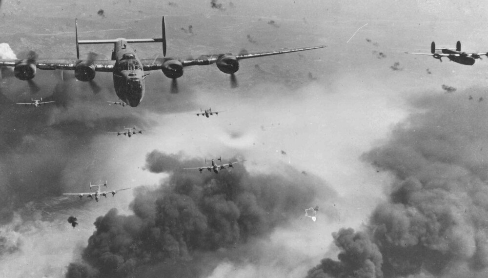 450 amerikanske B-24 Liberator-fly brøler inn over Omaha Beach, men slipper bombelasten sin for tidlig. 450 amerikanske B-24 Liberator-fly brøler inn over Omaha Beach, men slipper bombelasten sin for tidlig.