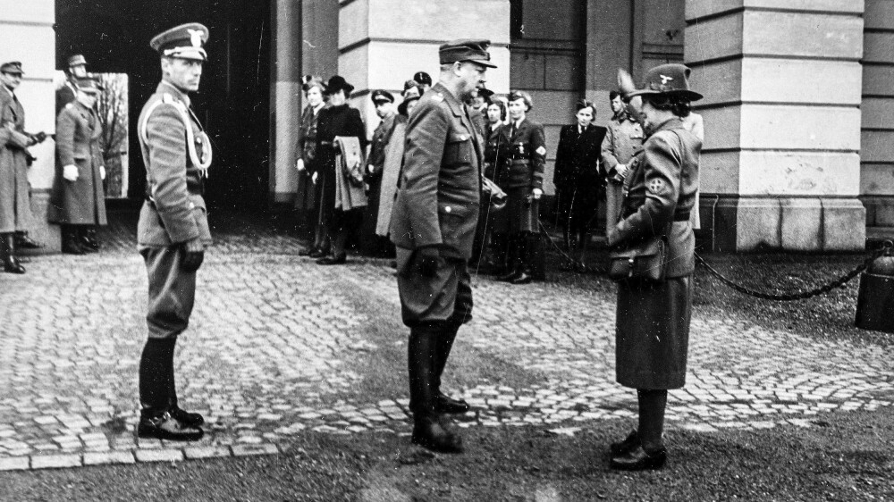 HEIL OG SÆL – Olga Bjoner hilser Vidkun Quisling med utstrakt arm utenfor Slottet. HEIL OG SÆL – Olga Bjoner hilser Vidkun Quisling med utstrakt arm utenfor Slottet.