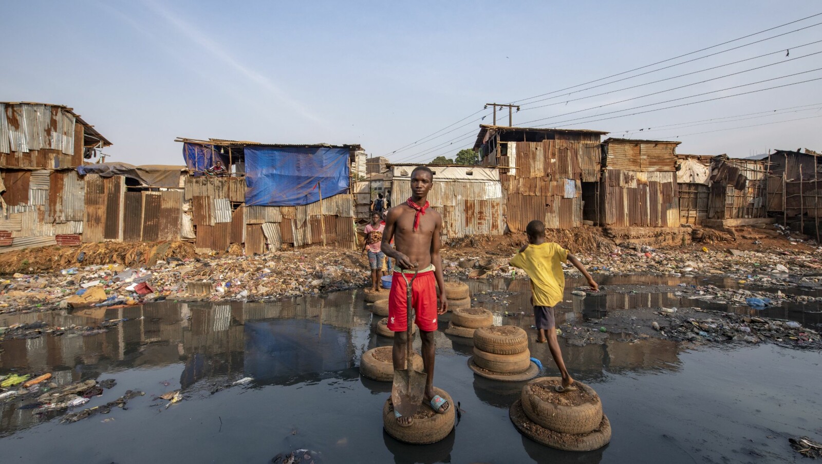 <b>BOMPENGER:</b> – Du må betale litt for å passere! Abdul laget en improvisert overgang. Broen som stod her er falt sammen. Inne i Kro Bay slummen, Freetown. <b>BOMPENGER:</b> – Du må betale litt for å passere! Abdul laget en improvisert overgang. Broen som stod her er falt sammen. Inne i Kro Bay slummen, Freetown.