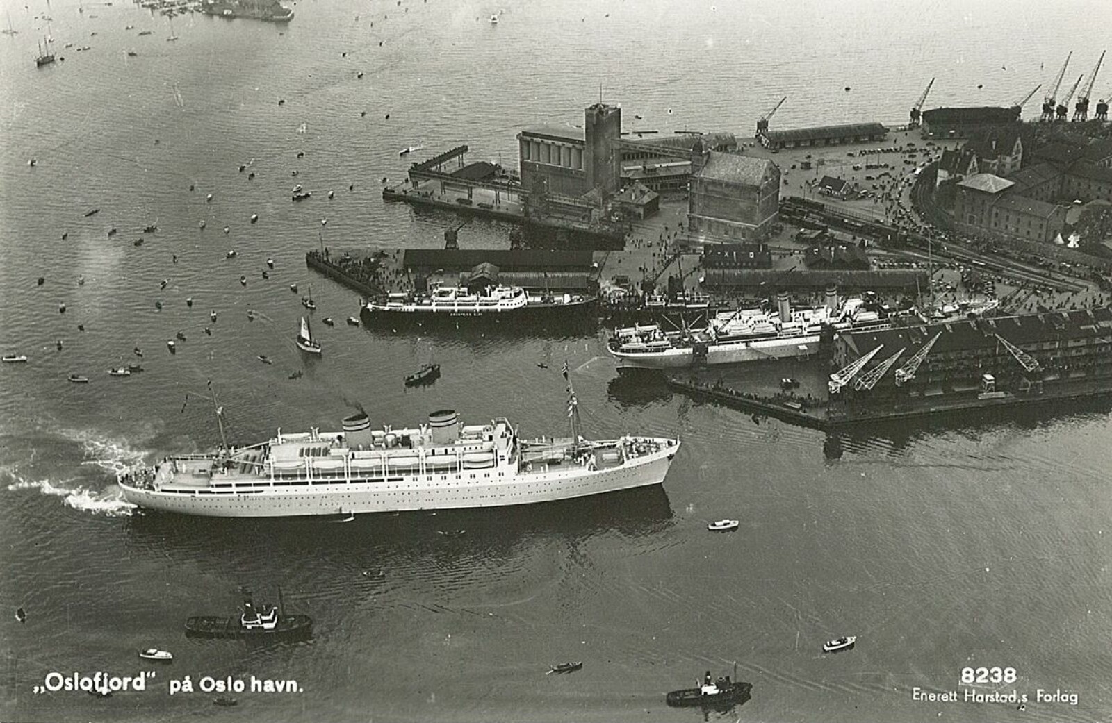<b>VIPPETANGEN:</b> Dette bildet skal være tatt i løpet av perioden fra «Kronprins Olav» ble satt i rute og til hun ble lagt i opplag i Danmark. I forgrunnen ses amerikabåten SS «Oslo-fjord». Ved Den Norske Amerika-linjes kai ligger SS «Bergens-fjord», og ved utstikker II ses MS «Kronprins Olav». <b>VIPPETANGEN:</b> Dette bildet skal være tatt i løpet av perioden fra «Kronprins Olav» ble satt i rute og til hun ble lagt i opplag i Danmark. I forgrunnen ses amerikabåten SS «Oslo-fjord». Ved Den Norske Amerika-linjes kai ligger SS «Bergens-fjord», og ved utstikker II ses MS «Kronprins Olav».